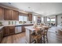 Well-lit kitchen features an island with seating, wood cabinets, and stainless steel appliances at 21945 E 51St Dr, Aurora, CO 80019