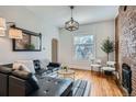 Bright living room featuring hardwood floors, brick wall accent, and plenty of natural light at 3427 W 29Th Ave, Denver, CO 80211