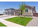 Exterior showcasing well-manicured lawn and a two-car garage at 18951 E 96Th Pl, Commerce City, CO 80022
