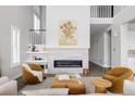 Cozy living room boasts a modern fireplace, two-story ceilings, and neutral decor, creating a comfortable and inviting space at 533 Red Thistle Dr, Highlands Ranch, CO 80126