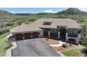 Gorgeous home with a three-car garage, stone detailing, steps to the entrance, and a lush landscape at 1272 Nightfire Cir, Castle Rock, CO 80104