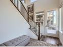 Bright entryway featuring wood floors, a staircase with black metal railings and a bench at 15646 W Floyd Dr, Morrison, CO 80465