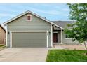 Well-maintained exterior with a large garage and manicured lawn at 268 Naples St, Firestone, CO 80520