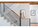 Modern staircase featuring sleek black railings and light, neutral-toned steps and walls at 160 Bristlecone, Boulder, CO 80304