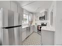 Modern kitchen featuring stainless steel appliances, stylish backsplash, and geometric-patterned flooring at 215 E 11Th Ave # D8, Denver, CO 80203