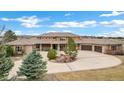 An exterior shot of a residence boasting a large circular driveway and desert landscaping at 5625 Twilight Way, Parker, CO 80134