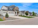 Exterior view showcasing the house, its three-car garage, well-kept lawn, and neighborhood at 1143 Williams Loop, Elizabeth, CO 80107
