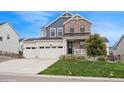 Charming two-story home showcasing a stone and siding facade with a three-car garage and manicured lawn at 1143 Williams Loop, Elizabeth, CO 80107