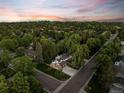 An aerial shot shows the home on a verdant lot, surrounded by lush mature trees in a quiet neighborhood at 2684 Taft Ct, Lakewood, CO 80215