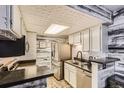 Cozy kitchen featuring white cabinets, modern appliances, and unique ceiling design at 4400 S Quebec St # 101N, Denver, CO 80237