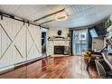 Comfortable living room features a stone fireplace, barn door, and shiny hardwood floors at 4400 S Quebec St # 101N, Denver, CO 80237