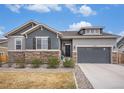 Charming home with a stone facade, two-car garage, and manicured landscaping at 11346 Kittredge St, Commerce City, CO 80022