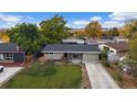 Aerial view of a well maintained home with large lawn, mature trees and a long driveway at 7911 Raleigh Pl, Westminster, CO 80030