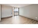 Empty bedroom featuring wood floors and sliding doors to a balcony at 955 Eudora St # 1107, Denver, CO 80220