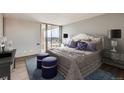Luxurious bedroom featuring a decorative headboard, stylish furniture, and sliding glass doors to a private balcony at 955 Eudora St # 1107, Denver, CO 80220