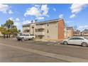 Tan two-story building with parking and trees at 10150 E Virginia Ave # 6-305, Denver, CO 80247