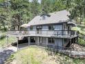 Beautiful multi-level deck offers outdoor living space with surrounding mountain views on this two-story home at 30221 Marge Ln, Evergreen, CO 80439