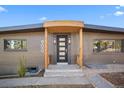 Front entrance boasts modern door with glass panels and wooden overhang at 900 S Webster St, Lakewood, CO 80226