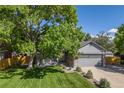 Attractive home with a lush green lawn, mature tree, and charming front porch at 11760 Eudora Ct, Thornton, CO 80233