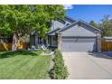Inviting home exterior featuring a well-kept lawn, mature tree, and a two-car garage at 11760 Eudora Ct, Thornton, CO 80233