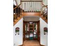 Grand foyer with hardwood floors, split staircase and french doors leading to the living room with a brick fireplace at 1332 Meadow Trl, Franktown, CO 80116