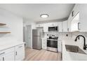 Bright kitchen with modern cabinets, stainless steel appliances, and stylish herringbone backsplash at 3470 S Poplar St # 401, Denver, CO 80224