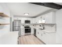Bright kitchen with modern cabinets, stainless steel appliances, and stylish herringbone backsplash at 3470 S Poplar St # 401, Denver, CO 80224