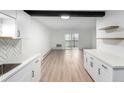 Open kitchen features long countertops, a view to the living room and door to the balcony at 3470 S Poplar St # 401, Denver, CO 80224