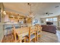 Open dining area with rustic chandelier, seamlessly connected to the kitchen and living spaces, bathed in natural light at 62 Broken Lance Dr # 202E, Breckenridge, CO 80424