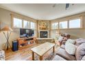 Comfortable living room showcasing a stone fireplace, wood-framed windows, and a traditional wood coffee table at 62 Broken Lance Dr # 202E, Breckenridge, CO 80424