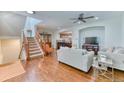 Spacious living room with hardwood floors, a cozy fireplace, and staircase leading to the second floor at 6365 Orion Ct # B, Arvada, CO 80403