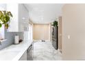 Bright kitchen featuring stainless steel appliances, marble floors, and ample cabinet space at 1459 S Pierce St, Lakewood, CO 80232