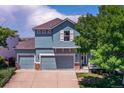 Charming blue two-story home with a three-car garage and well-maintained landscaping at 12535 S Beaver Creek Way, Parker, CO 80134