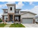 Charming home with a welcoming porch and stone detailing leading to a two-car garage at 5964 E 141St Ave, Thornton, CO 80602
