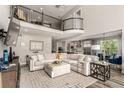 Spacious open-concept living room with high ceilings, a loft and modern furnishings at 5964 E 141St Ave, Thornton, CO 80602