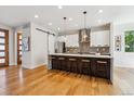 Modern kitchen boasts stainless appliances, bright white cabinets, and a large island with seating at 1911 S Lafayette St, Denver, CO 80210