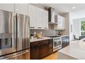 The kitchen features stainless steel appliances and a modern design with dark wood and white cabinets at 1911 S Lafayette St, Denver, CO 80210