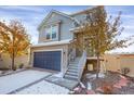 A delightful two-story home featuring a blue garage door, gray siding, and charming front entrance staircase at 17938 E 54Th Ave, Denver, CO 80249