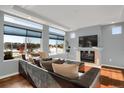 Spacious living room with fireplace, hardwood floors, and large windows offering abundant natural light and neighborhood views at 17938 E 54Th Ave, Denver, CO 80249