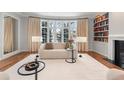 Bright living room featuring a large bay window, fireplace, custom bookshelf, and hardwood floors at 425 Monroe St, Denver, CO 80206