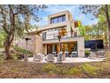 Modern back patio with seating area, stone accents, and beautiful views of surrounding trees at 1250 Dolan Dr, Monument, CO 80132