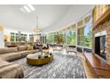 Open-concept living room with floor-to-ceiling windows and a stone fireplace at 1250 Dolan Dr, Monument, CO 80132