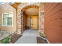 Charming front entrance with a stone archway and a welcoming yellow door at 8626 Gold Peak Dr # B, Highlands Ranch, CO 80130