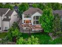 Aerial view of a home with a large deck, mature trees, and a well-maintained yard at 12350 Turquoise Terrace St, Castle Pines, CO 80108