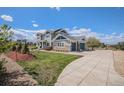 Beautiful two-story home featuring a long driveway and a two-car garage, surrounded by lush landscaping at 7692 Weaver Cir, Castle Rock, CO 80104