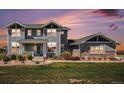 Charming two-story home boasts a well-manicured lawn and a welcoming front porch entrance at sunset at 7692 Weaver Cir, Castle Rock, CO 80104