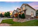 A charming home showcasing a well-maintained lawn, attractive landscaping, and a blend of brick and stucco exterior at 7038 Russell Ct, Arvada, CO 80007