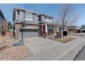 Charming home featuring a two-car garage, gray siding, brick accents, and a well-manicured lawn at 15675 E Kettle Pl, Centennial, CO 80112