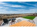 Outdoor living with a concrete patio featuring a fire pit, dining set, and scenic backyard views at 490 Silver Rock Trl, Castle Rock, CO 80104