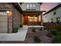 Inviting front porch with hanging flower baskets, a seating area, and attractive landscaping at 7949 S Elk Way, Aurora, CO 80016
